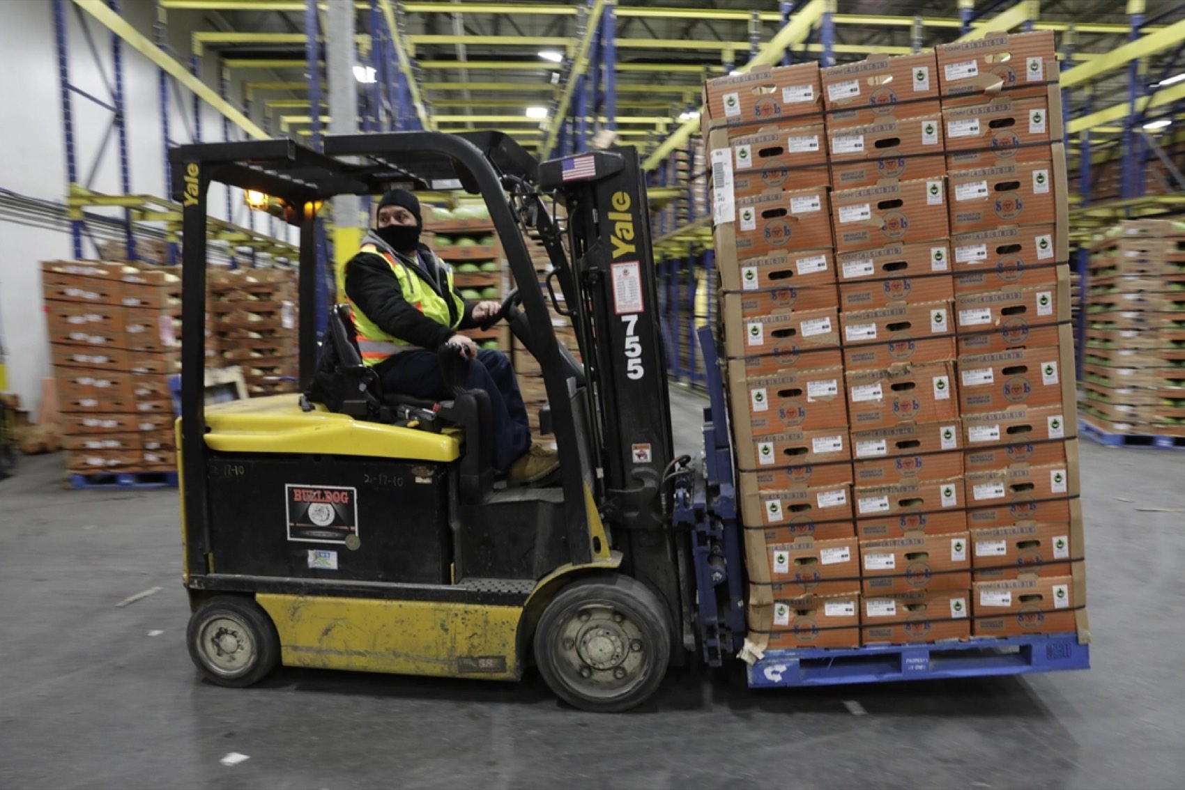 Forklift moving a loaded pallet through a warehouse